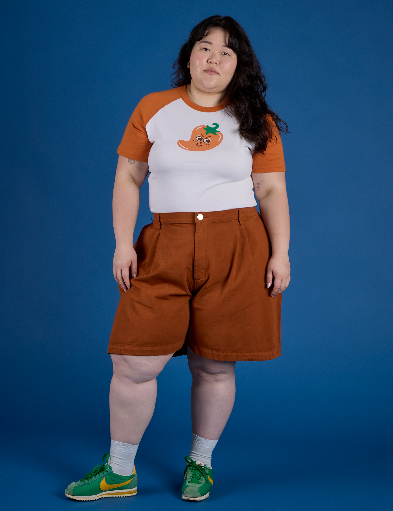 Ashley is wearing Produce Raglan Tee in Habanero