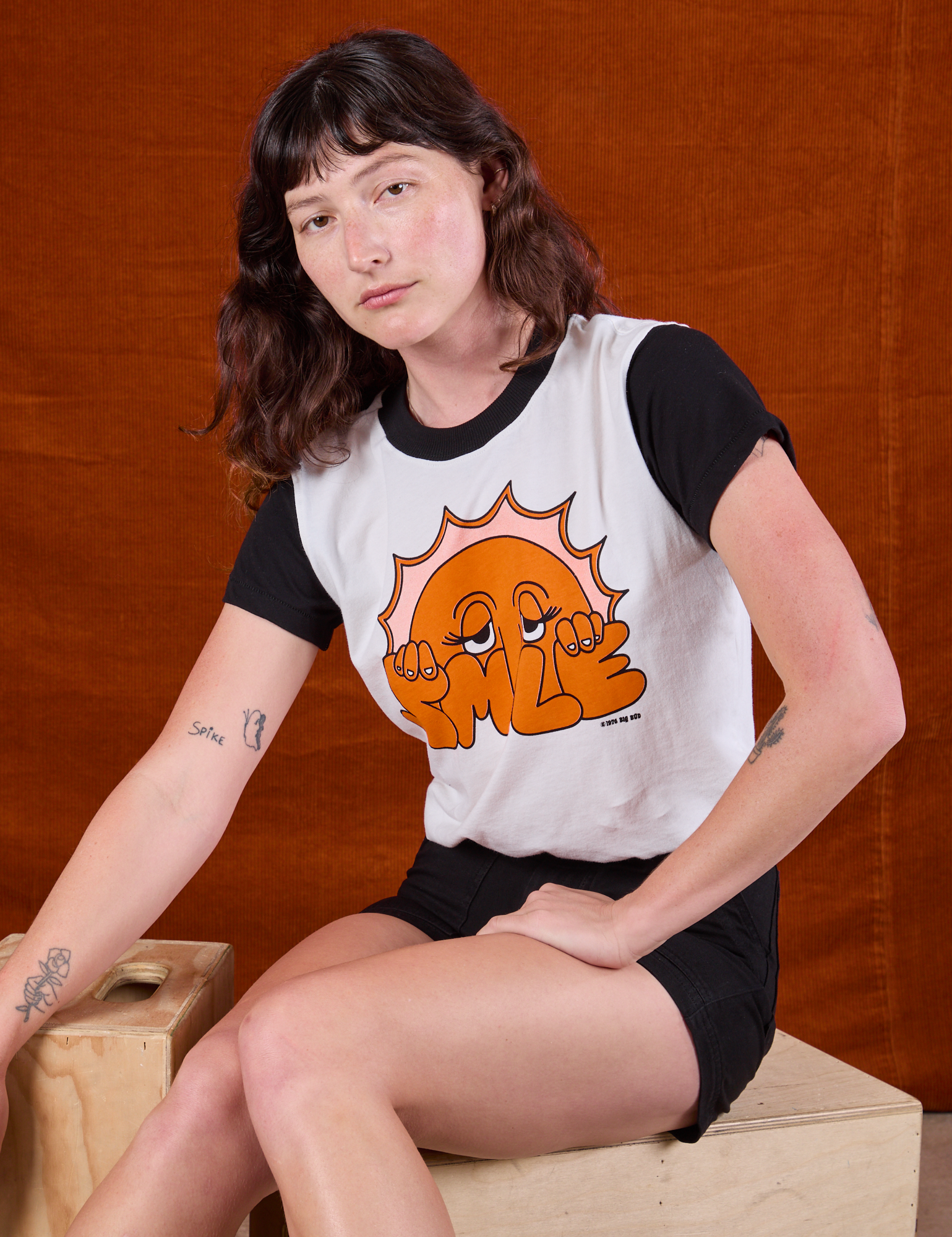 Alex is wearing Anniversary Tee in Smile and black Work Shorts