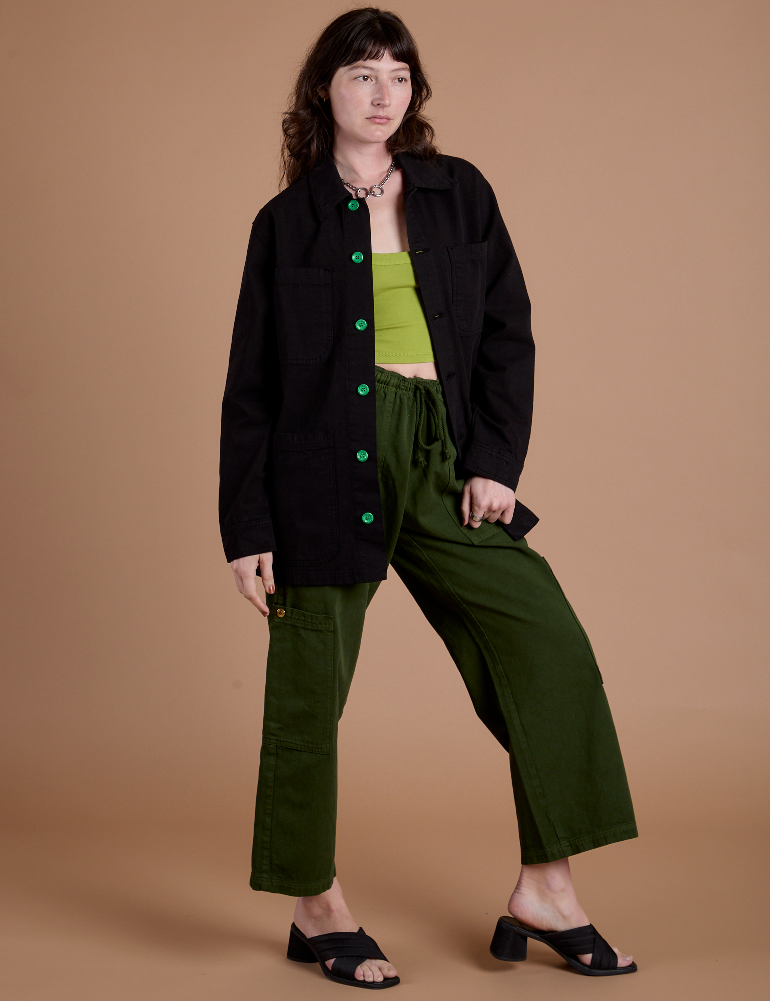 Alex is wearing Ripstop Field Coat in Basic Black paired with evergreen Drop Pocket Cargo Pants