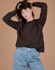 Alex is wearing Long Sleeve Burly Tee in Espresso Brown tucked into light wash Indigo Wide Leg Trousers