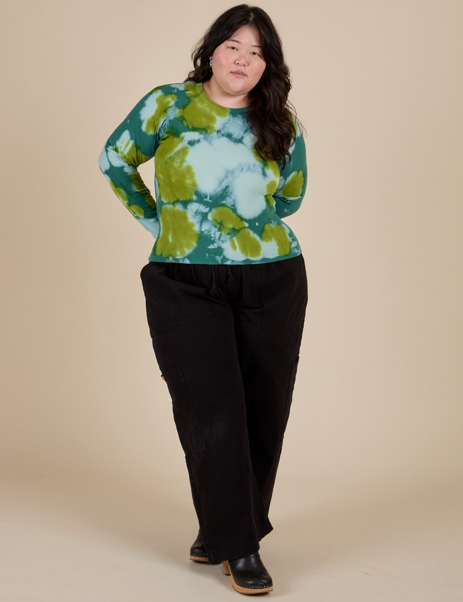 Ashley is wearing Long Sleeve Baby Tee in Green Magic Waters and black Drop Pocket Cargo Pants