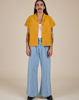 Anthony is wearing Pantry Button-Up in Mustard Yellow and light wash Indigo Wide Leg Trousers