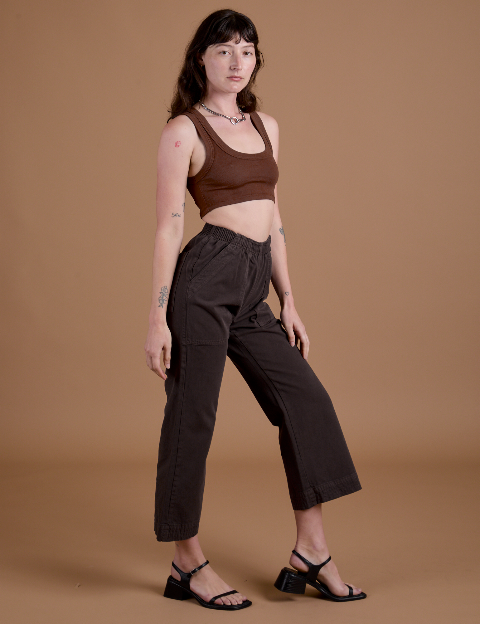 Side view of Work Pants in Espresso Brown and fudgesicle brown Mini Tank on Alex