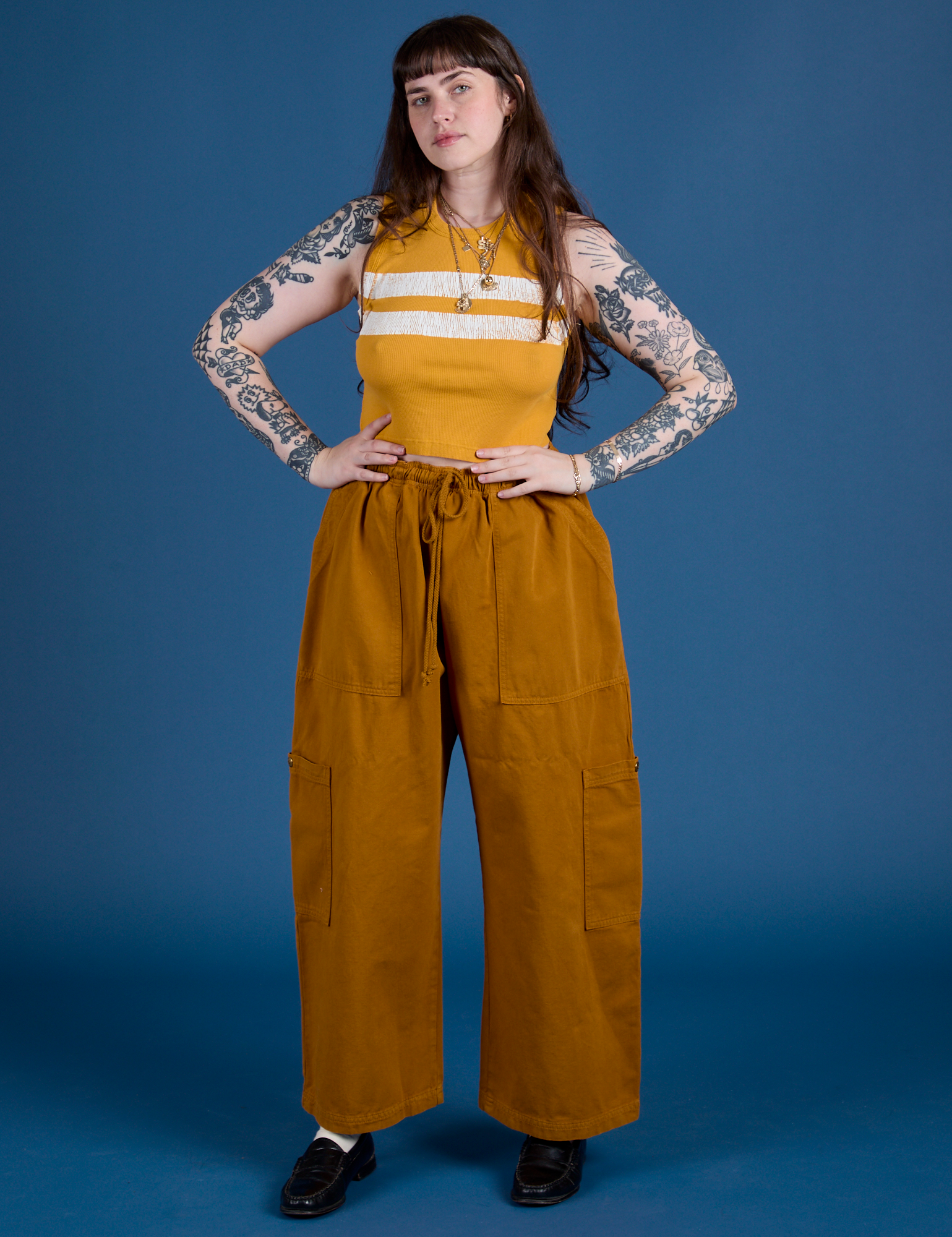 Sydney is wearing  Painted Muscle Tee in Mustard Yellow and spicy mustard Drop Pocket Cargo Pants
