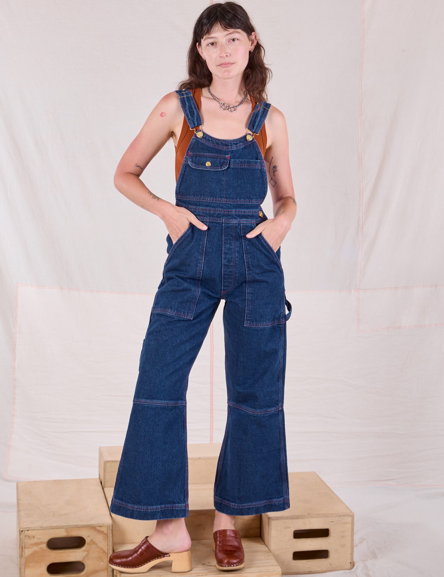 Alex is 5'8" and wearing XXS Carpenter Overalls in Dark Wash