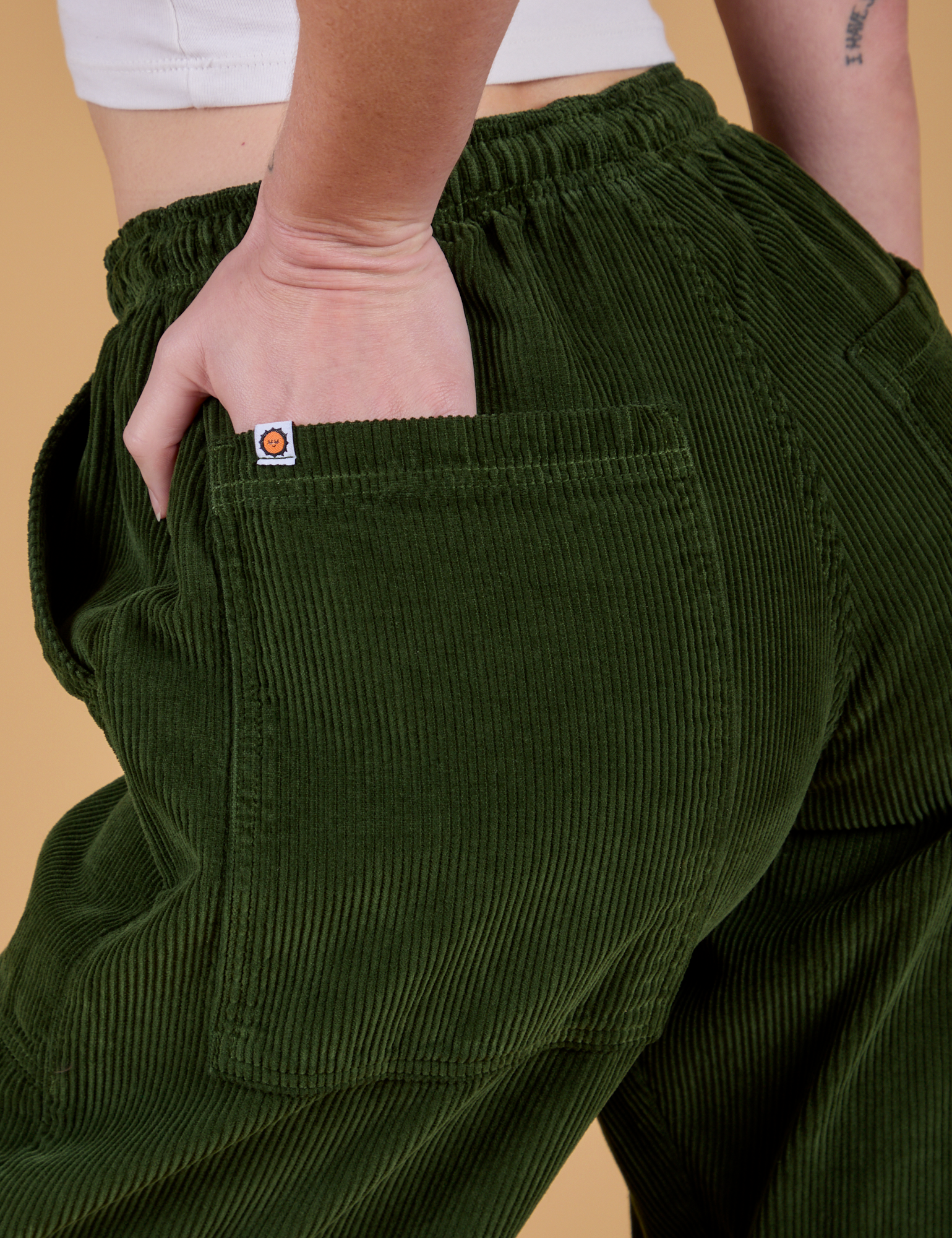 Close up of Alex's hand in the back pocket of Corduroy Drop Pocket Cargo Pants in Evergreen