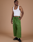 Angled front view of Denim Drop Pocket Pants in Green Overdye and Cropped Tank in Vintage Tee White