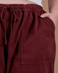Drop Pocket Cargo Pants in Red Wine front pocket close up with Ashley's hand tucked in