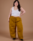 Ashley is 5'7" and wearing 1XL Drop Pocket Cargo Pants in Spicy Mustard paired with vintage tee white Cropped Tank