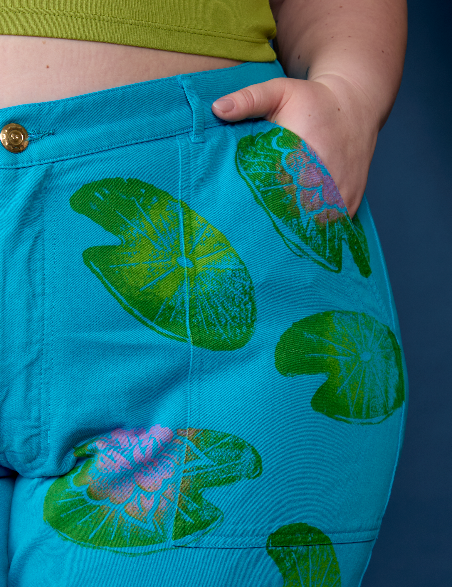 Close up of Ashley's hand in the front pocket of Paintstamped Work Pants in Lilypad