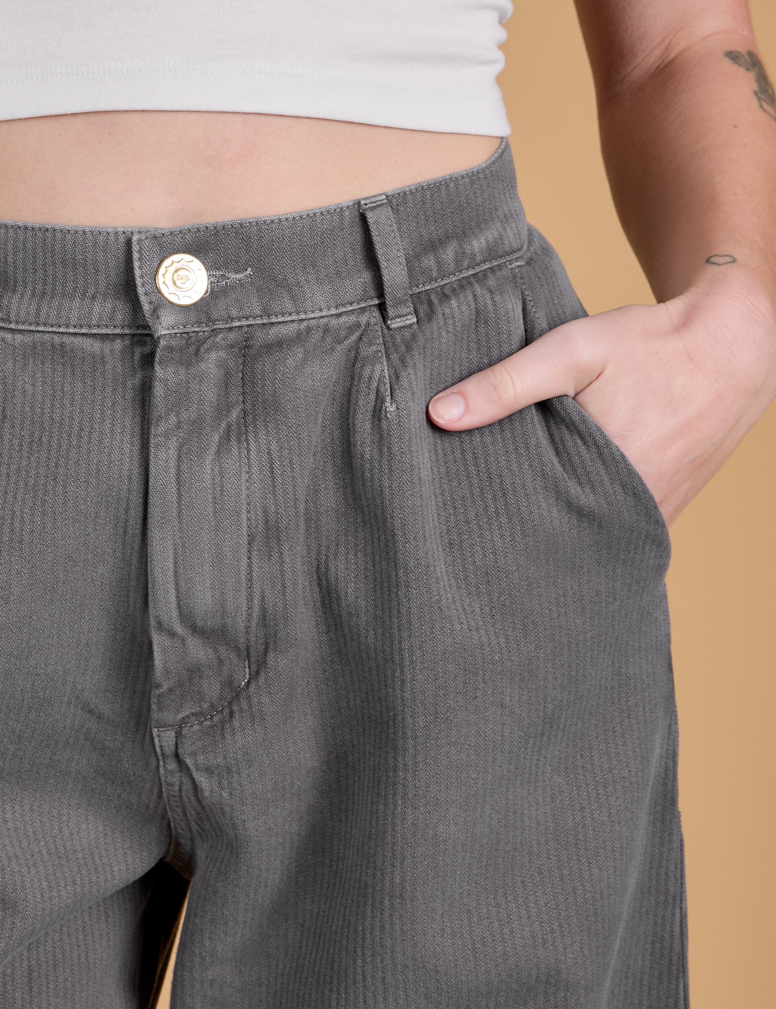 Close up of Alex's hand in the front pocket of Heritage Wide Leg Trousers in Washed Grey