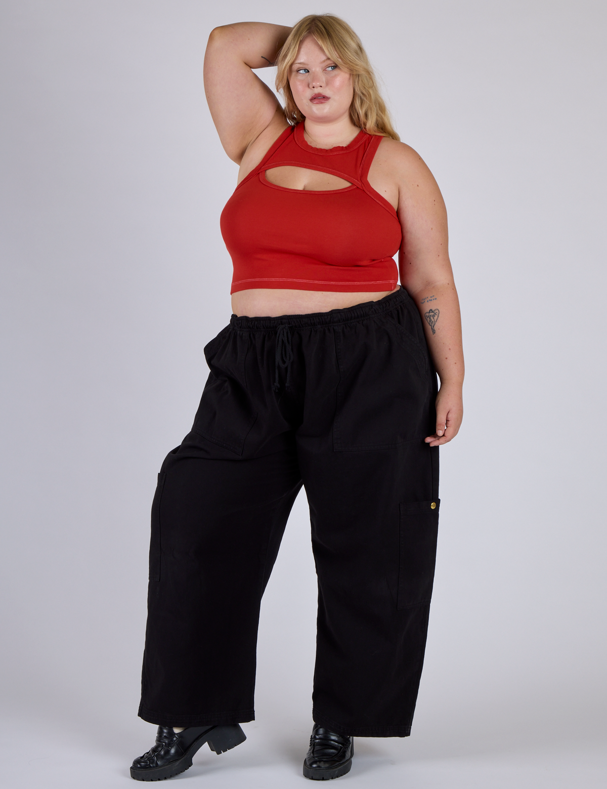 Juliet is wearing Porthole Tank in Mustang Red and black Drop Pocket Cargo Pants