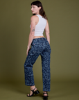 Angled back view of Lazy Daisy Mid-Rise Carpenter Jeans and vintage tee white Cropped Tank on Alex