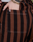 Close up of Sydney's hand in the back pocket of Longline Work Shorts in Fudgesicle Brown