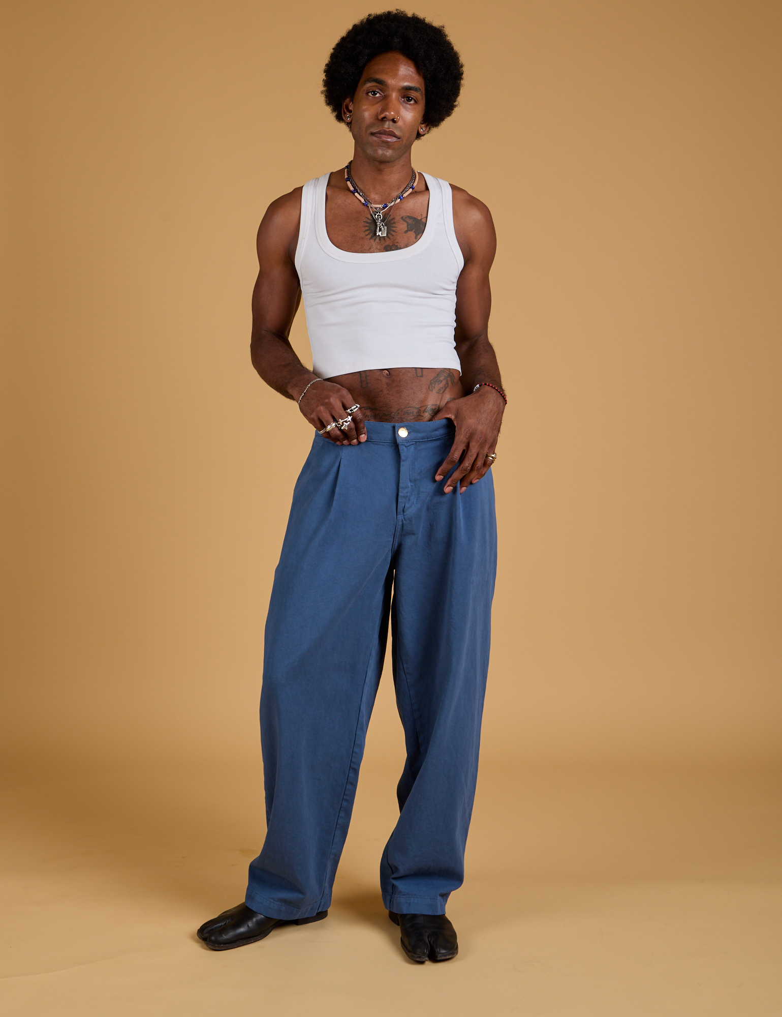 Jerrod is 6'3" and wearing M Baggy Mid-Rise Trousers in French Blue paired with a vintage tee white Cropped Tank