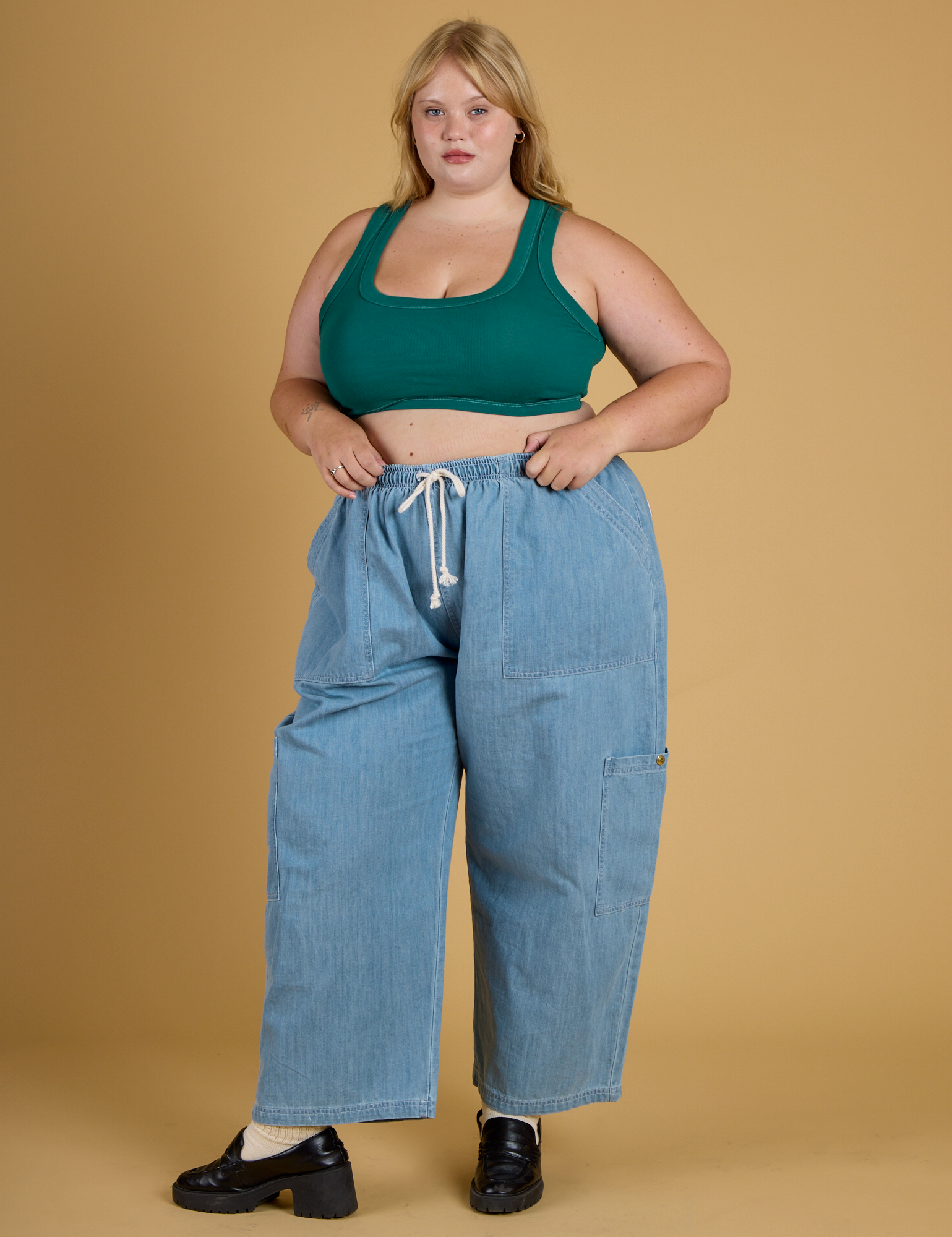 Juliet is wearing Contrast Stitch Mini Tank in Hunter Green paired with light wash Denim Drop Pocket Pants