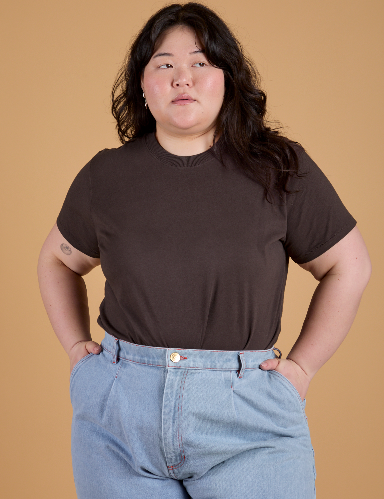 Ashley is wearing Organic Vintage Tee in Espresso Brown tucked into light wash Indigo Wide Leg Trousers
