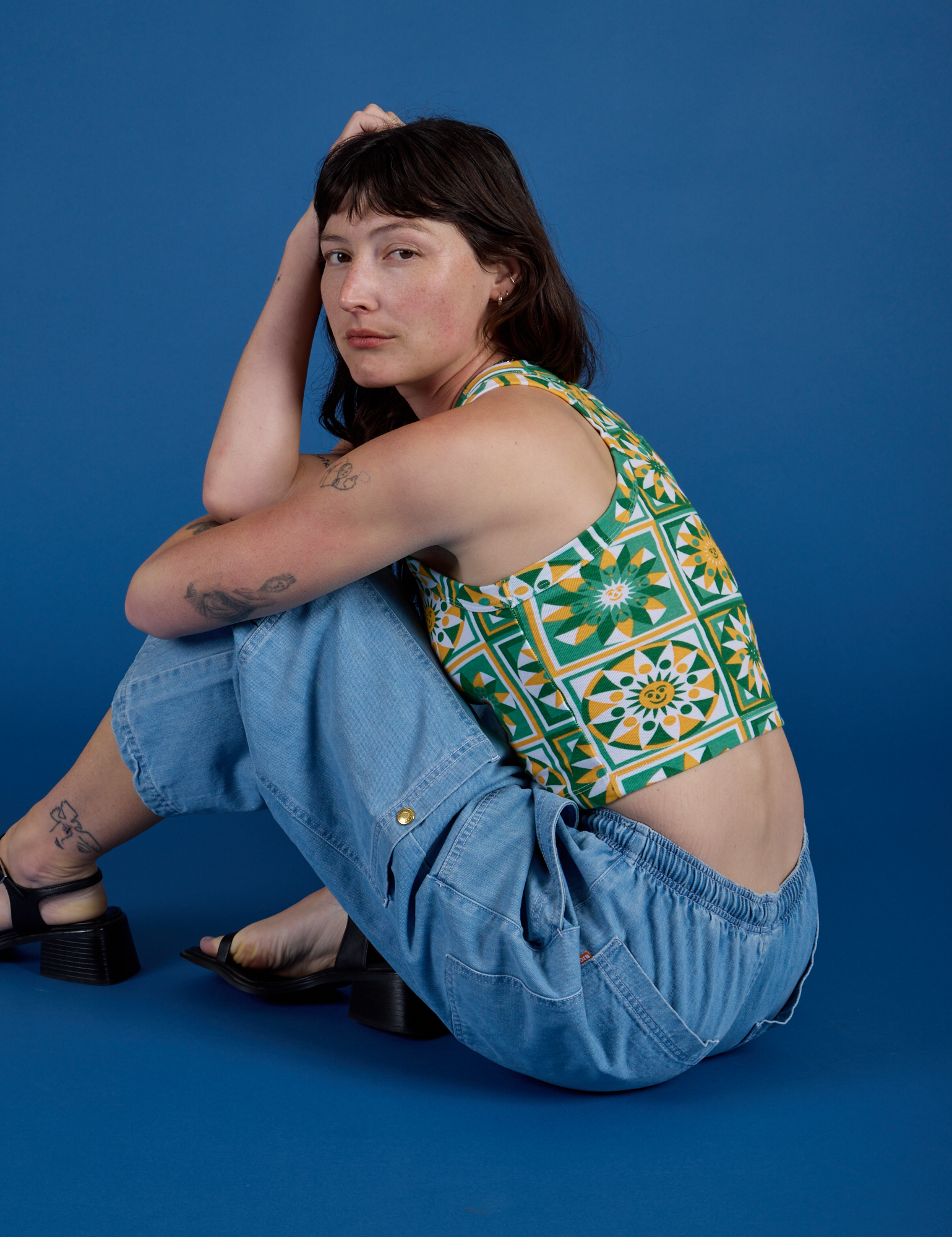 Alex is wearing  Deep-Cut Racerback Tank in Spring Quilt Print and light wash Denim Drop Pocket Cargo Pants
