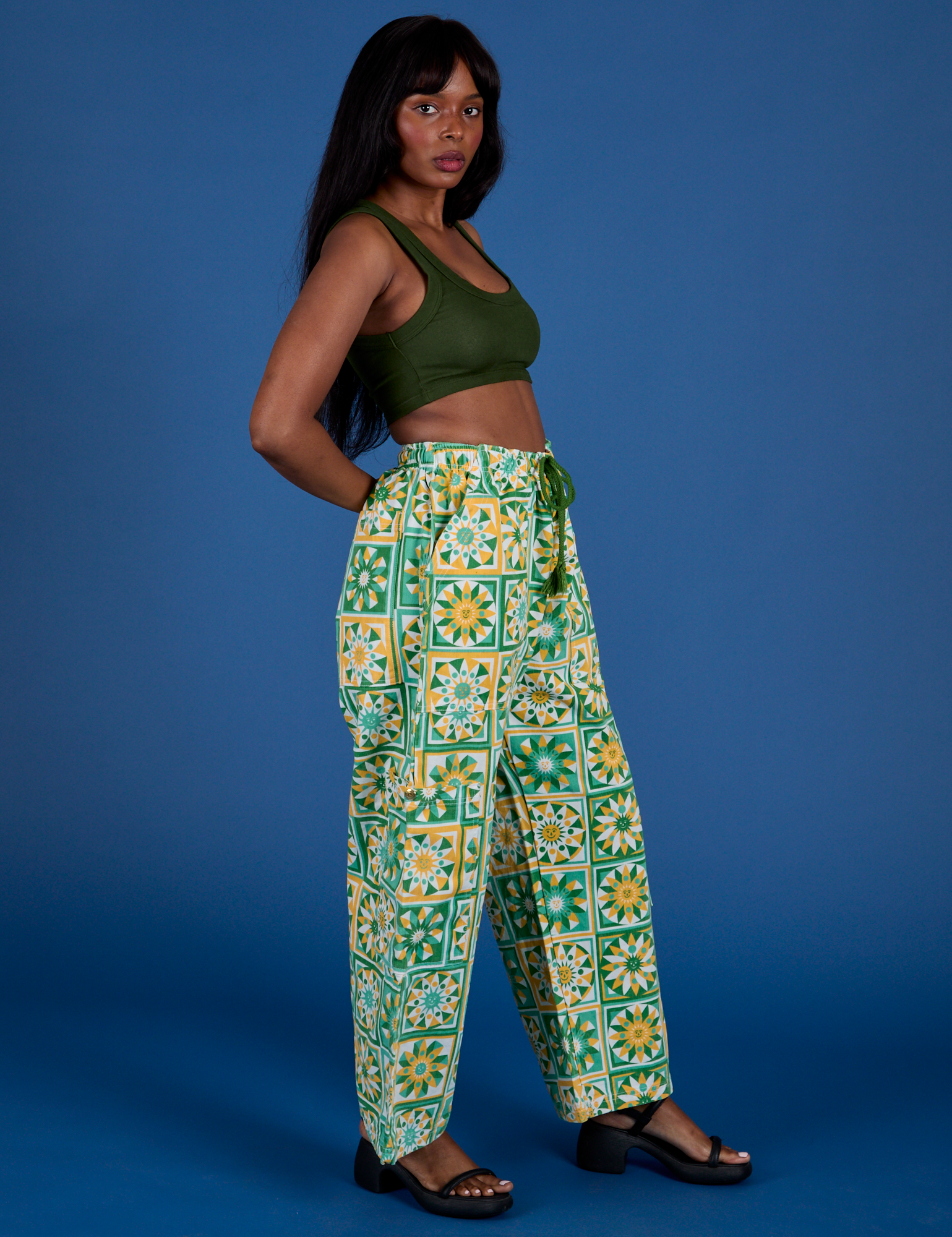 Side view of Drop Pocket Cargo Pants in Spring Quilt Print and evergreen Mini Tank on Kandia