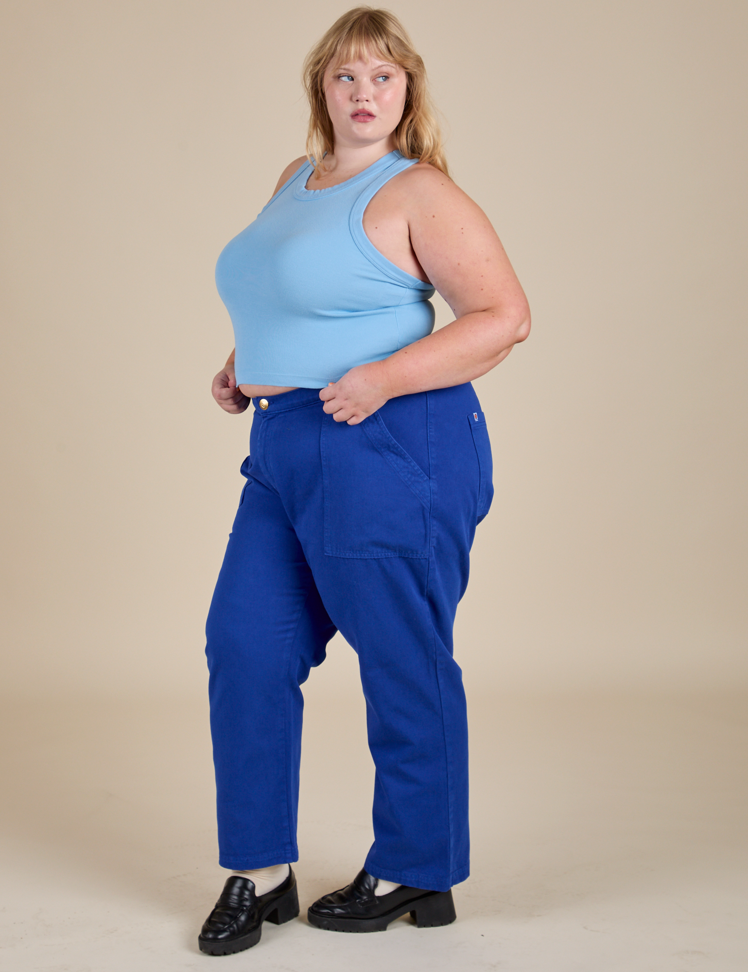 Angled front view of Racerback Tank in Baby Blue and royal blue Work Pants on Juliet