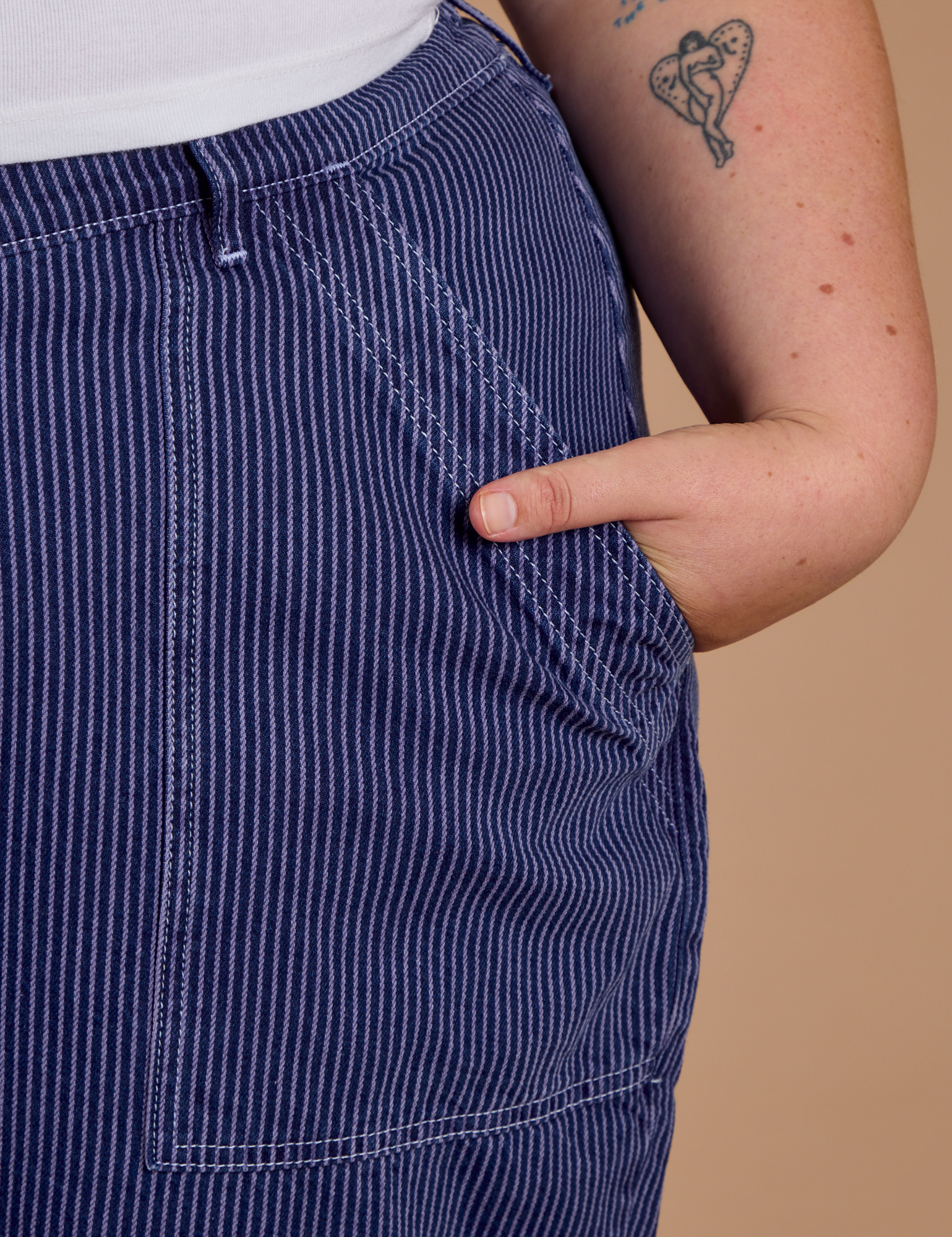 Close up of Juliet's hand in the front pocket of Railroad Denim Work Pants in Faded Grape Overdye 