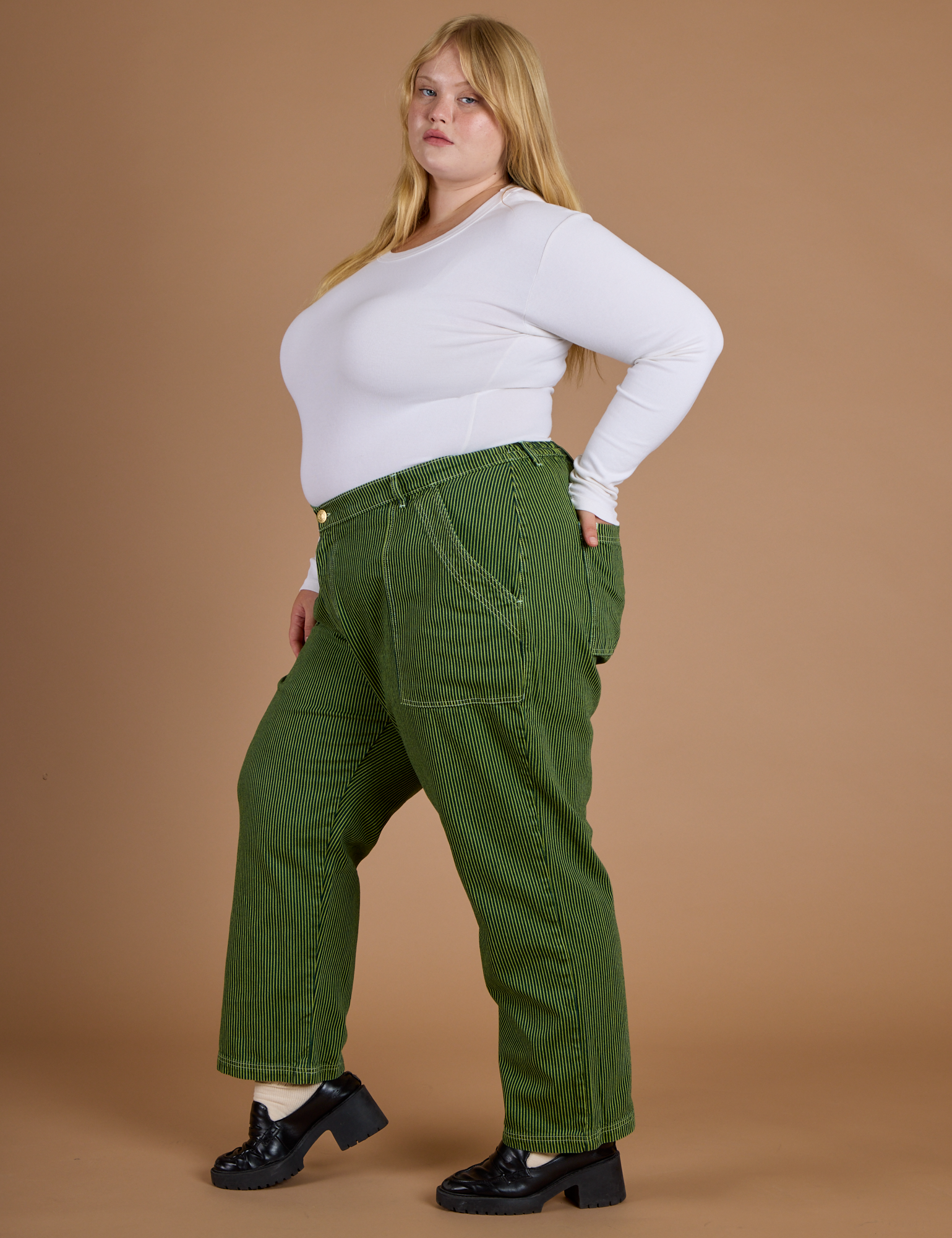 Side view of Railroad Denim Work Pants in Gross Green Overdye and vintage tee white long sleeve baby tee on Juliet