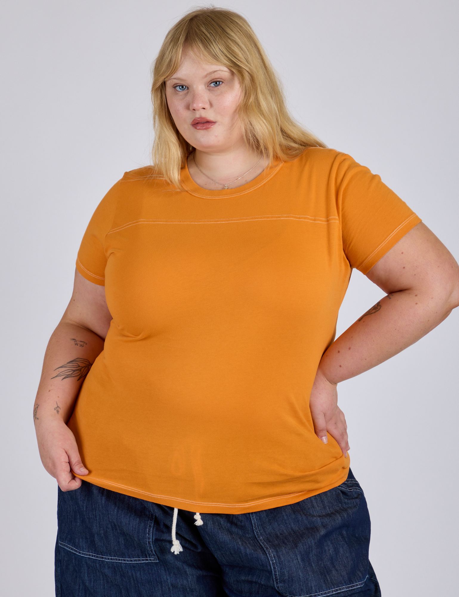 Juliet is 5’7” and wearing L Jr. Varsity Tee in Creamsicle Orange