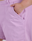 Close up of Juliet's hand in the front pocket of Longline Work Shorts in Lilac Purple
