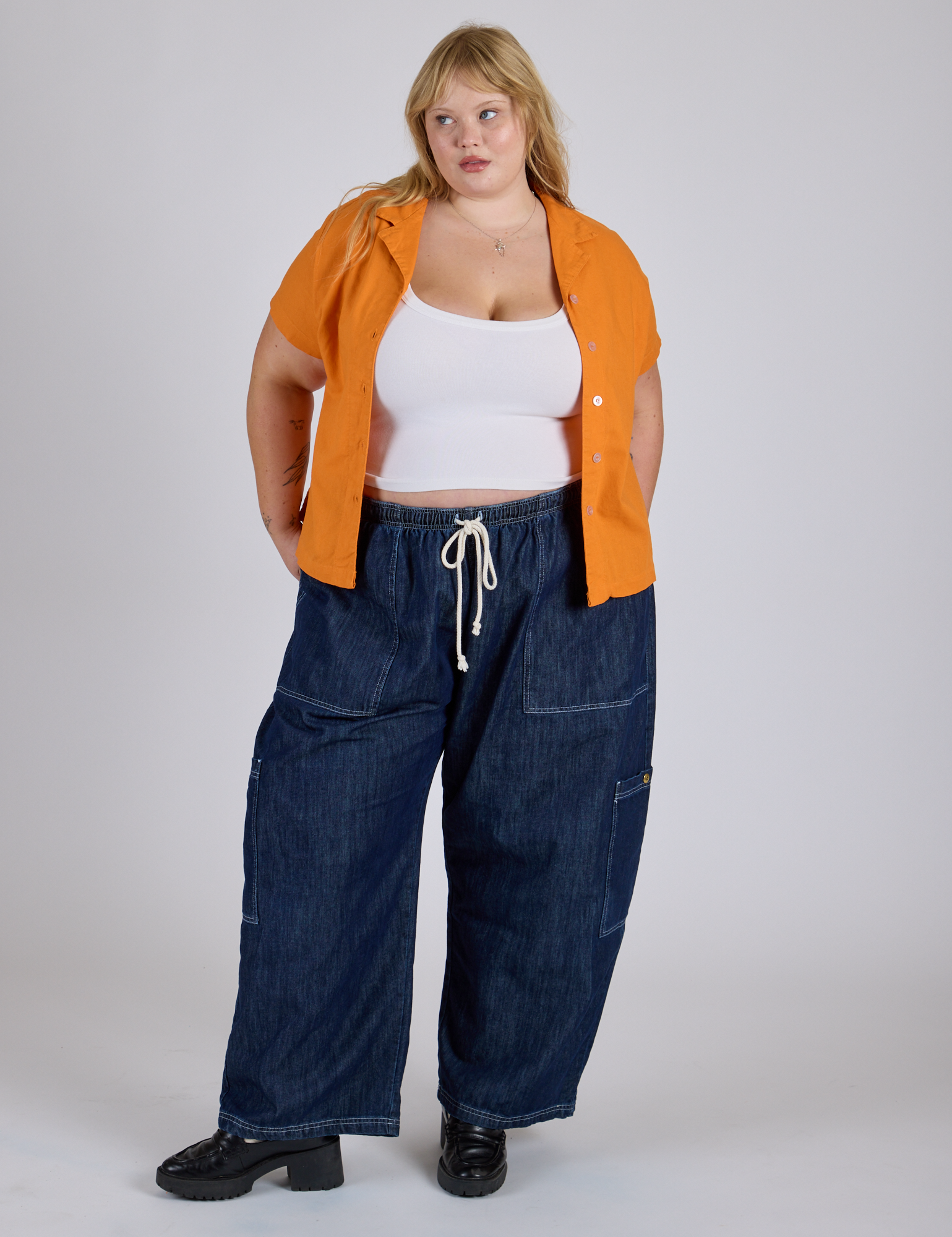 Juliet is wearing Pantry Button-Up in Creamsicle Orange and dark wash Denim Drop Pocket Pants