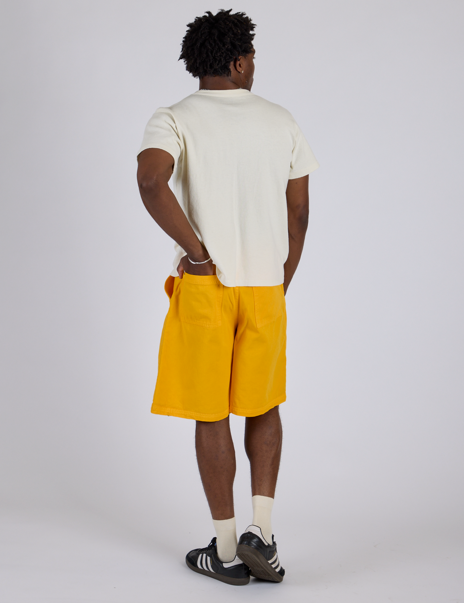 Angled back view of Longline Work Shorts in Sunshine Yellow and Burly Tee in Vintage Tee White