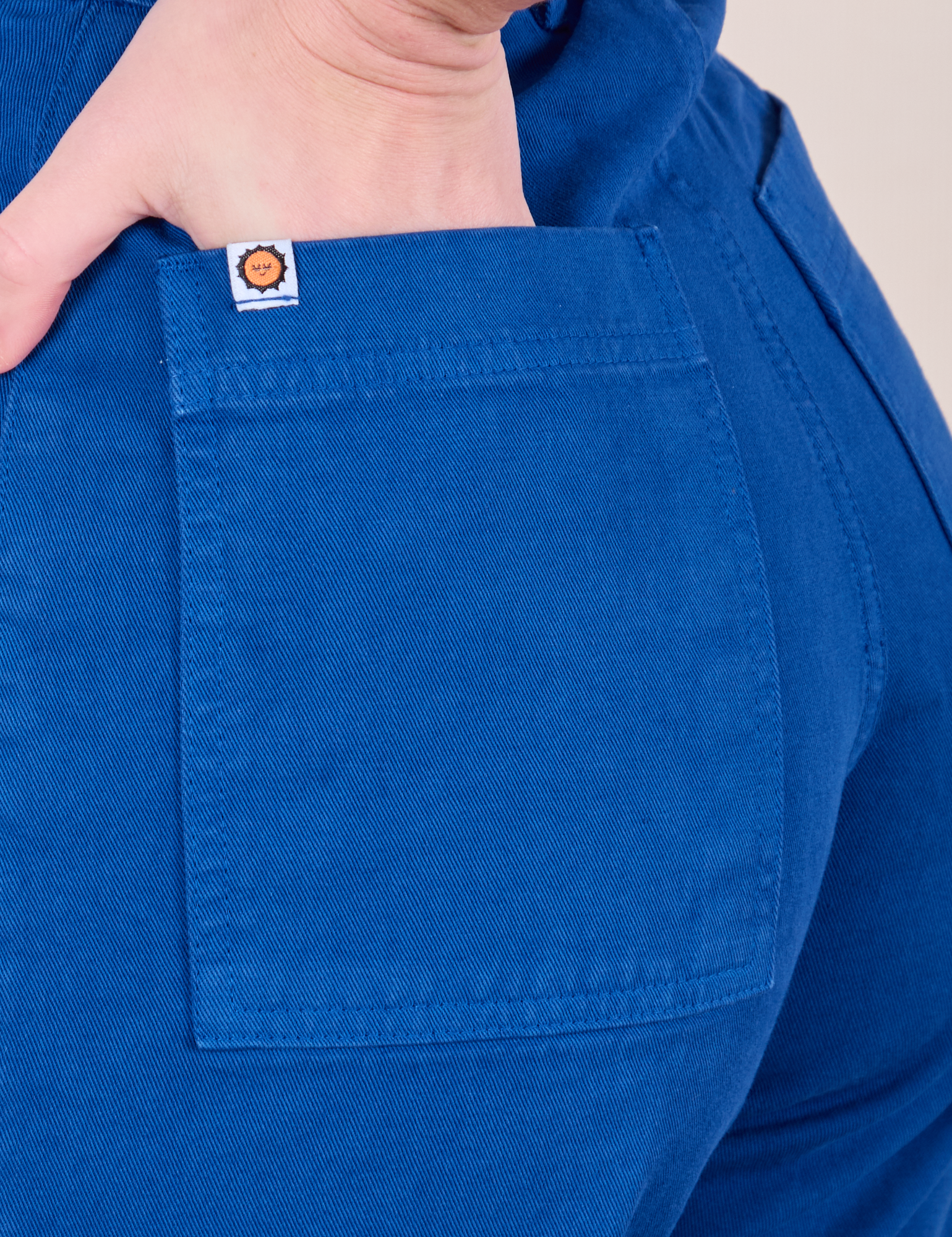Close up of Alex's hand in the back pocket of Western Pants in Royal Blue