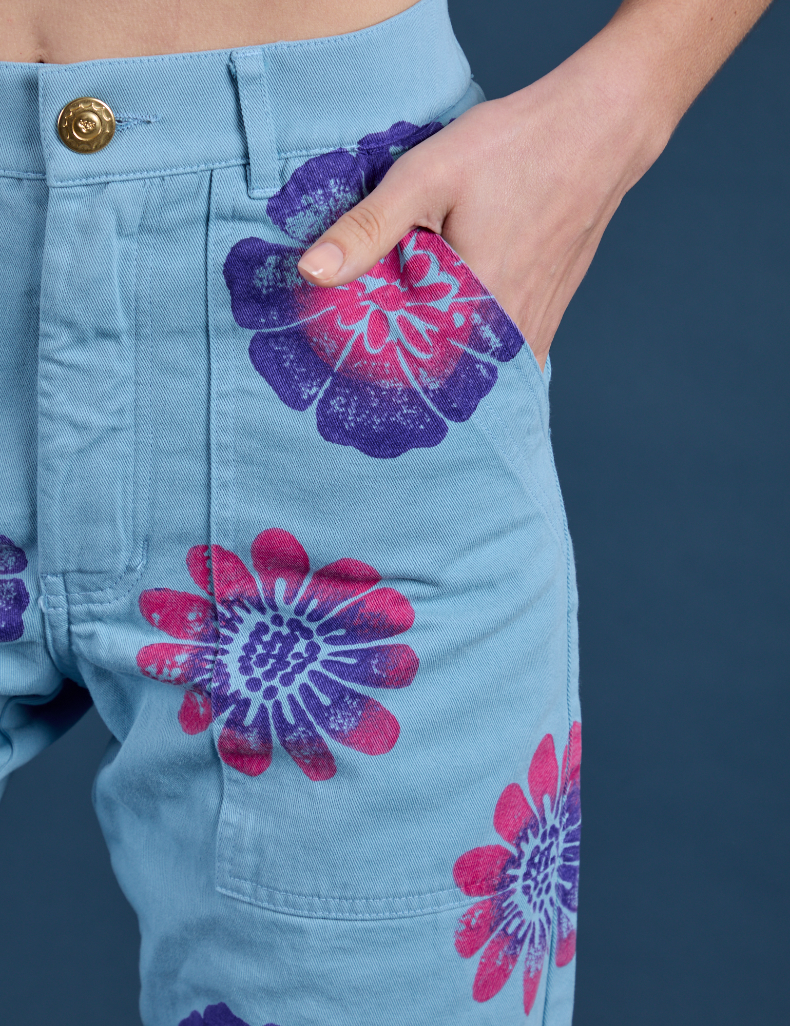 Close up of Madeline's hand in the front pocket of Floral Painted Work Pants in Blue