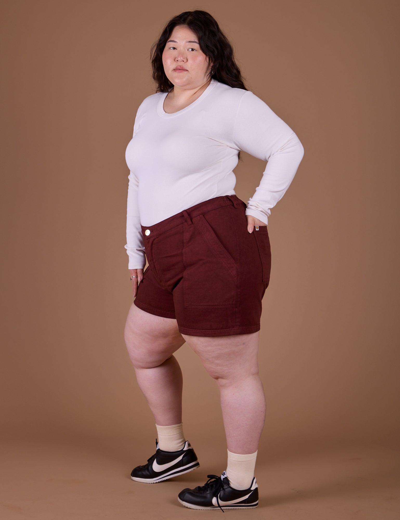 Side view of Classic Work Shorts in Red Wine and vintage tee white Long Sleeve Baby Tee on Ashley