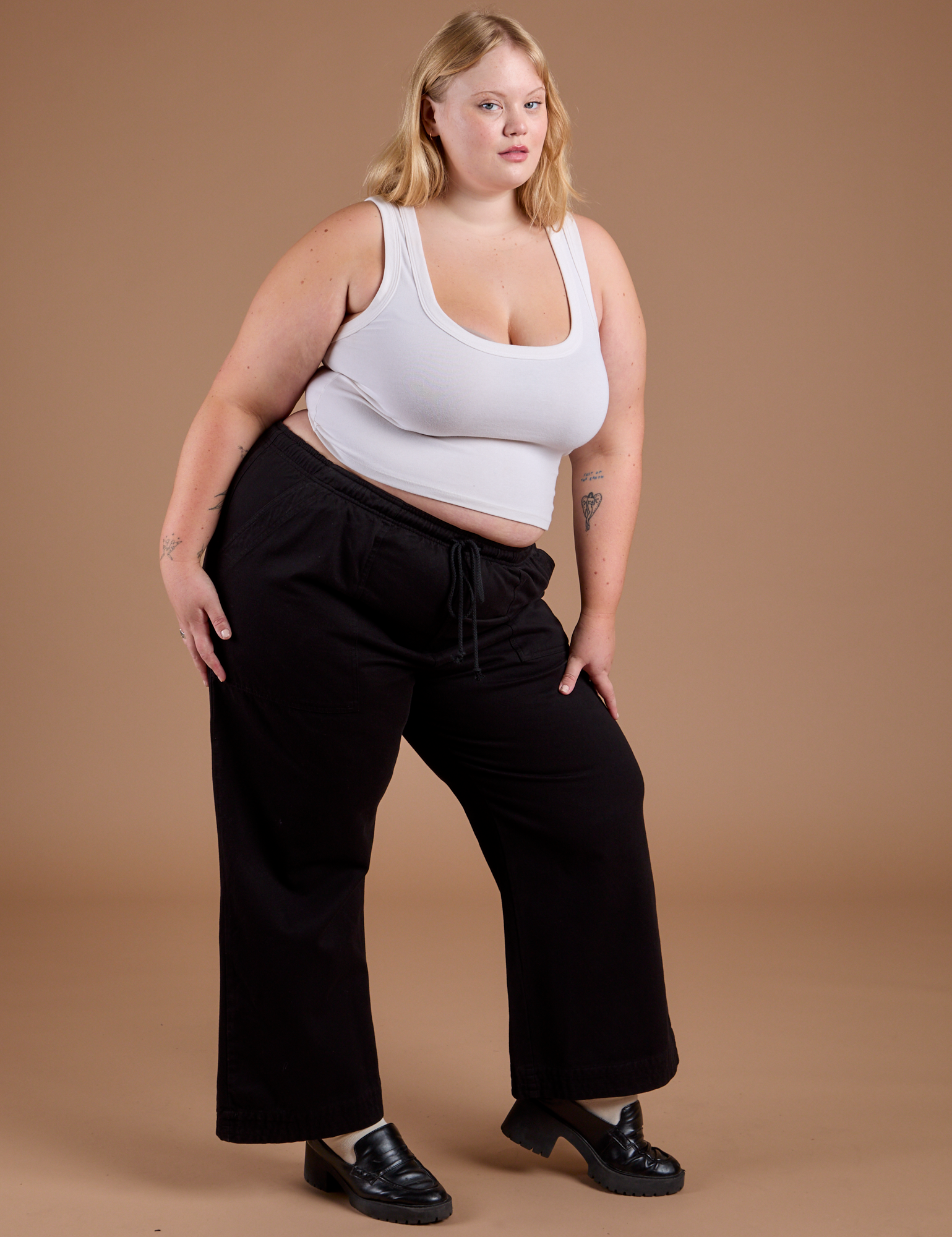 Angled front view of Organic Action Pants in Basic Black and vintage tee white Cropped Tank on Juliet