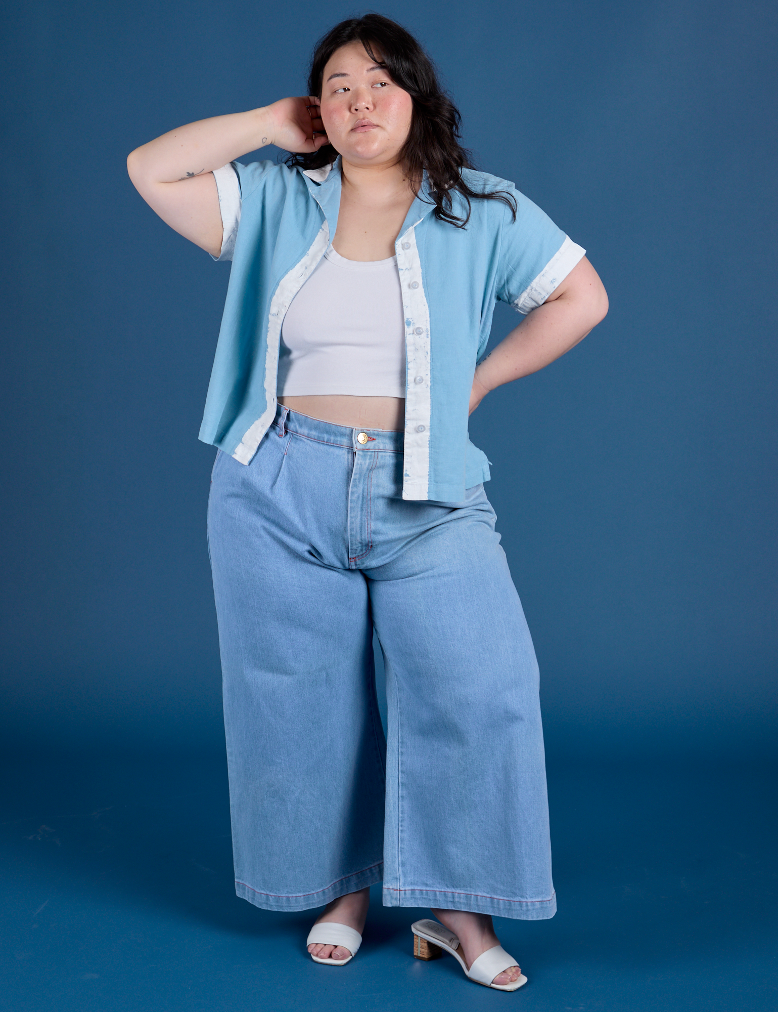 Ashley is wearing Painted Pantry Button-Up in Baby Blue and light wash Indigo Wide Leg Trousers