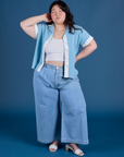Ashley is wearing Painted Pantry Button-Up in Baby Blue and light wash Indigo Wide Leg Trousers