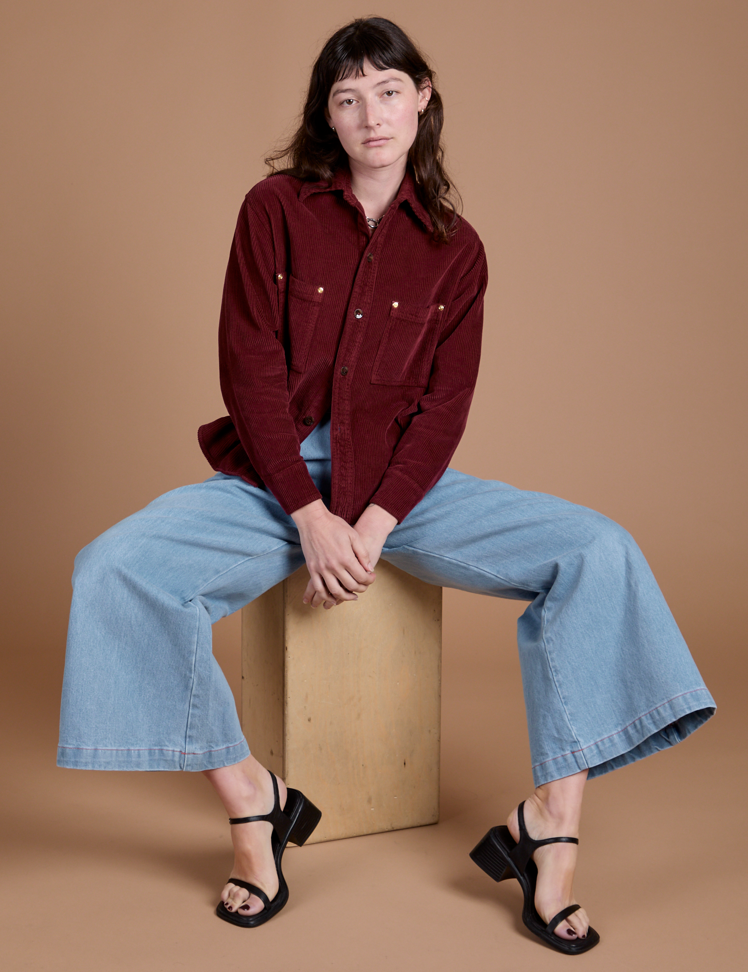 Alex is wearing Cropped Corduroy Overshirt in Red Wine and light wash Indigo Wide Leg Trousers