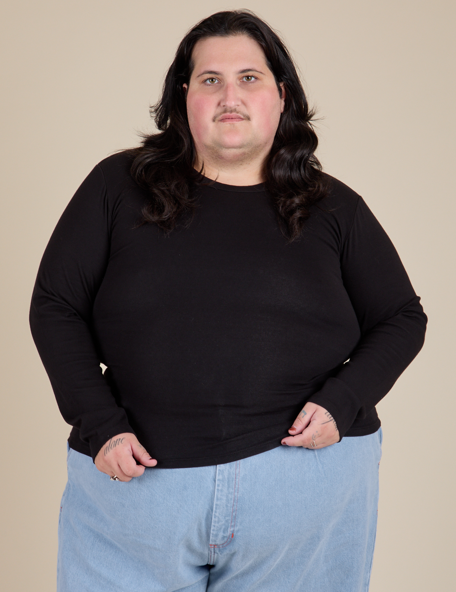 Sam is 5’10” and wearing XL Long Sleeve Baby Tee in Basic Black