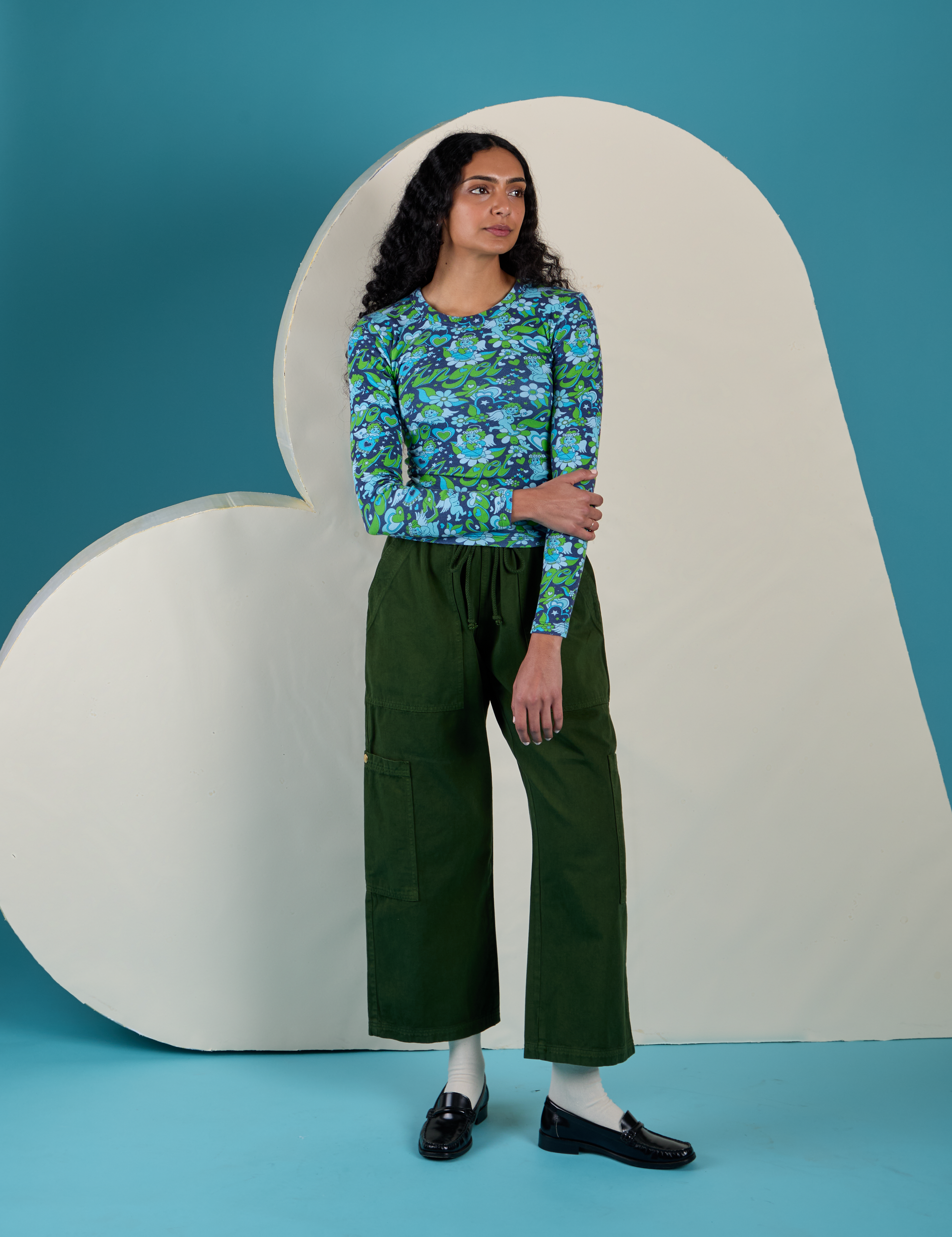 Shahana is wearing Long Sleeve Baby Tee in Angel Print paired with evergreen Drop Pocket Cargo Pants