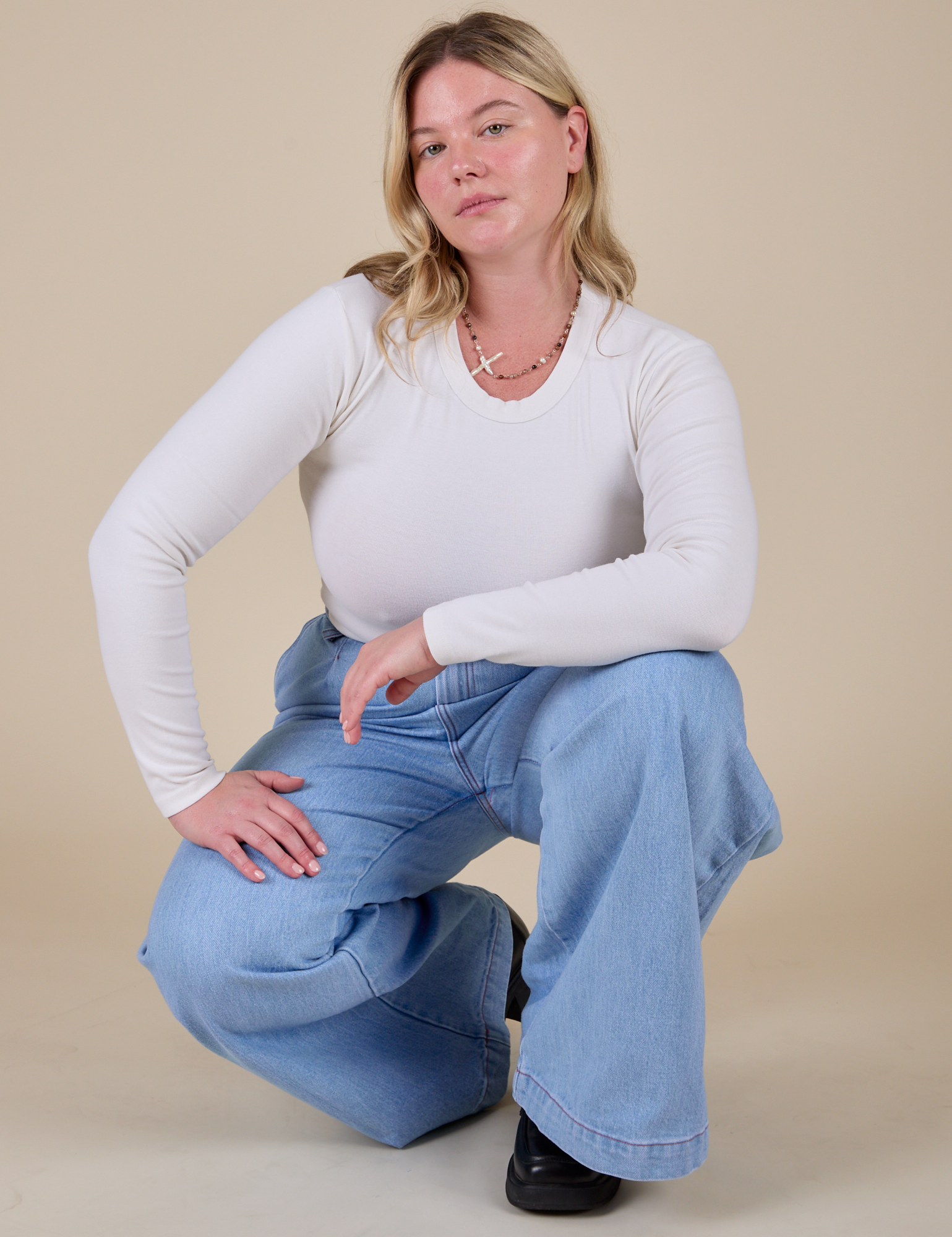 Lish is wearing Long Sleeve Baby Tee in Vintage Tee Off-White paired with light wash Indigo Wide Leg Trousers