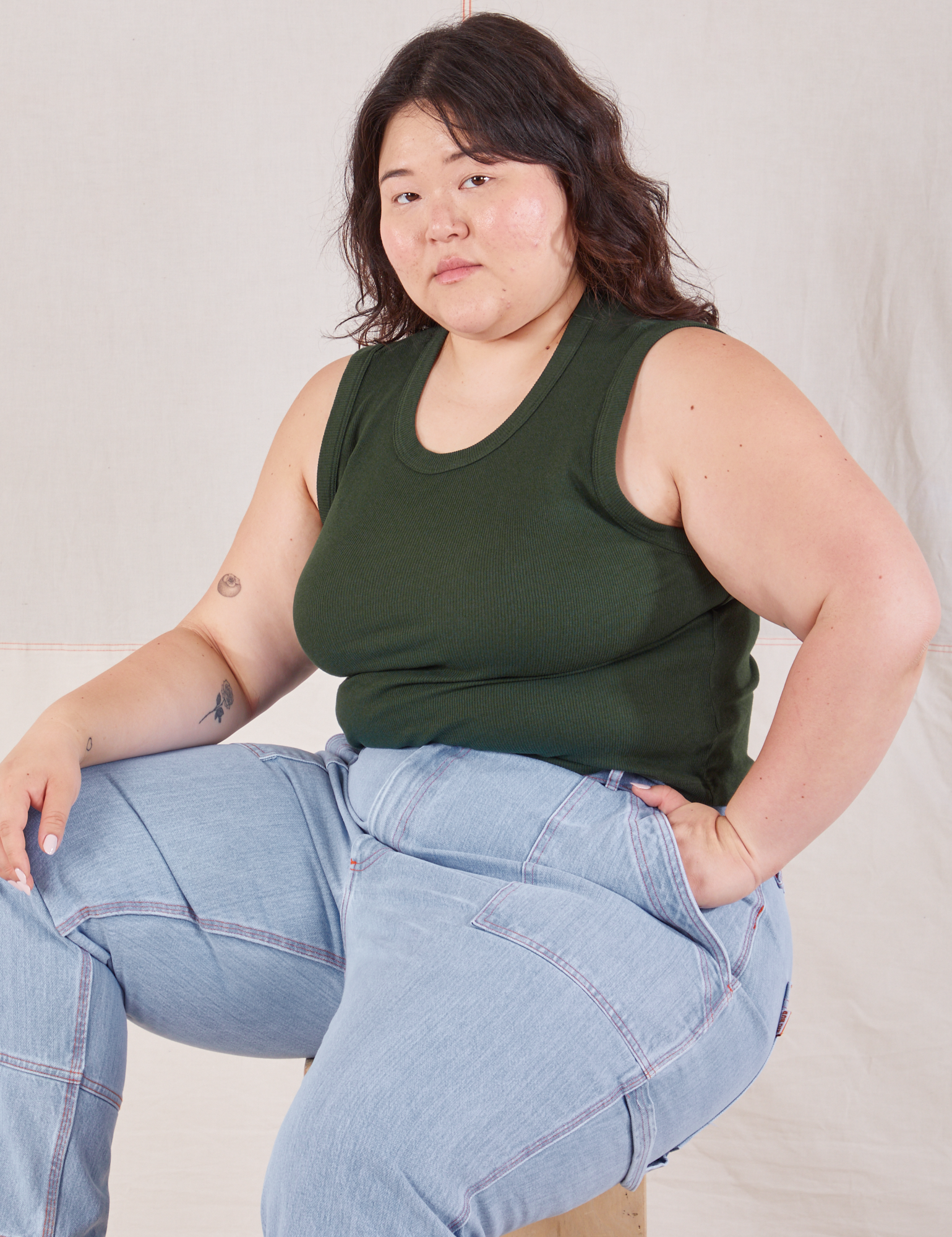Ashley is wearing Muscle Tee in Swamp Green and light wash Carpenter Jeans