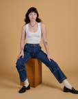 Alex is wearing Mid-Rise Carpenter Jeans in Dark Wash and Cropped Tank in Vintage Tee White