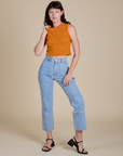 Alex is wearing Muscle Tee in Creamsicle Orange and light wash Carpenter Jeans