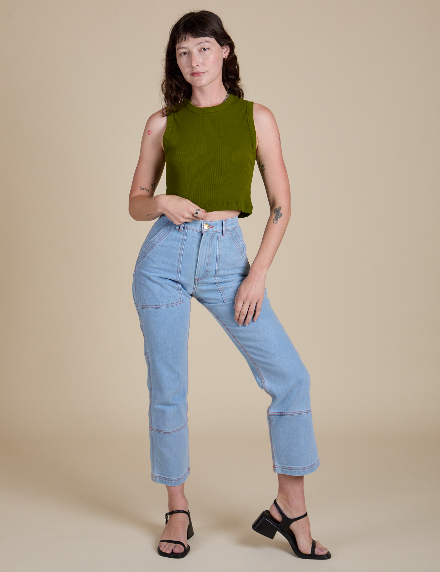 Alex is wearing Muscle Tee in Summer Olive and light wash Carpenter Jeans