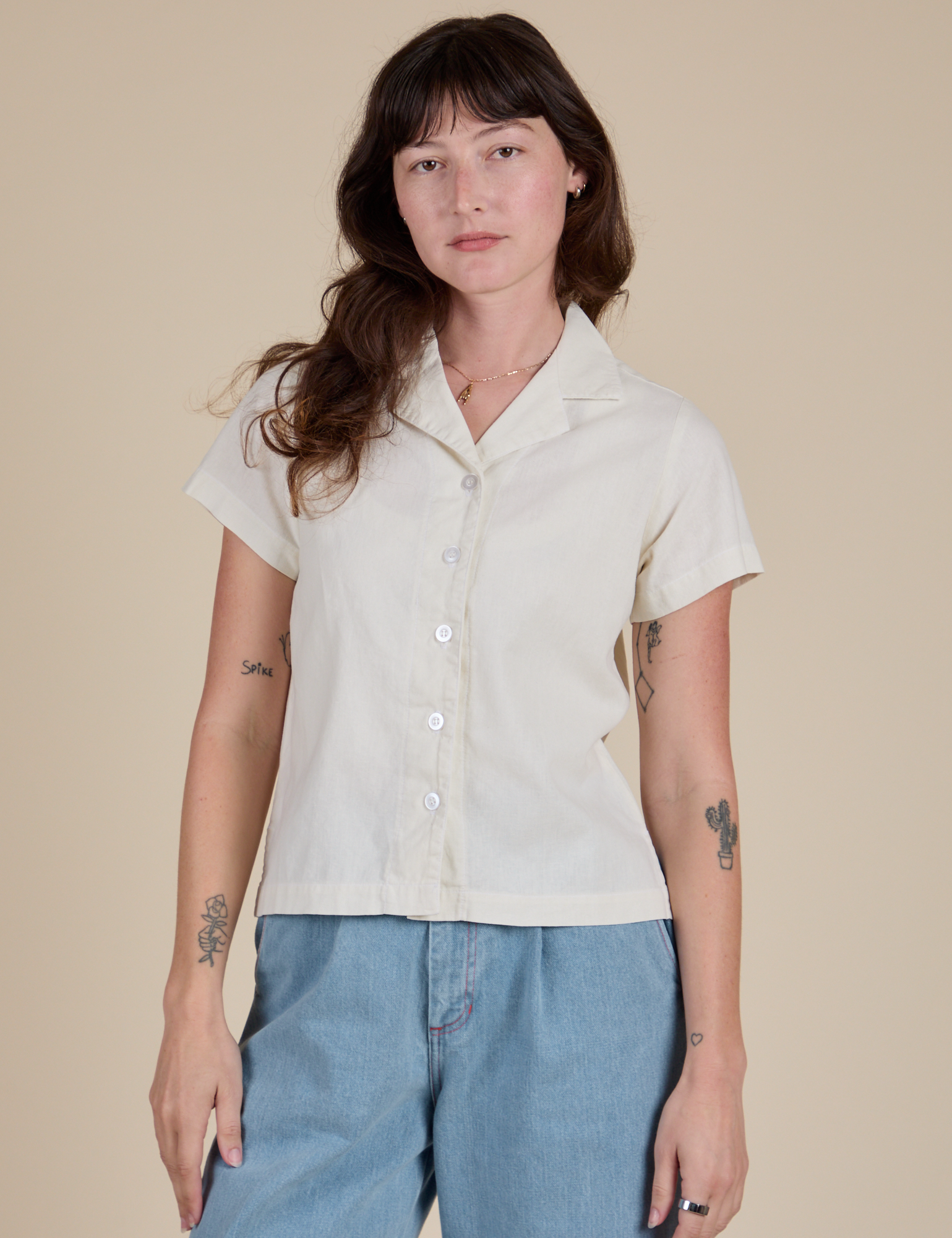 Alex is wearing a buttoned up Pantry Button-Up in Vintage Tee White