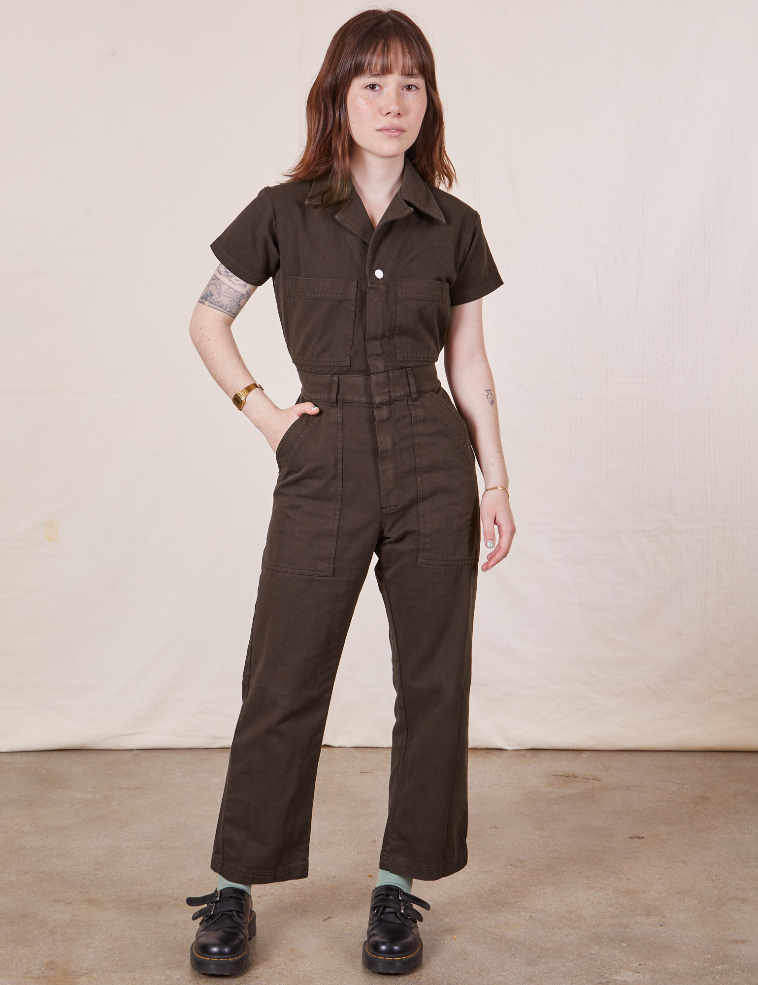 Hana is 5’3” and wearing XXS Petite Short Sleeve Jumpsuit in Espresso Brown