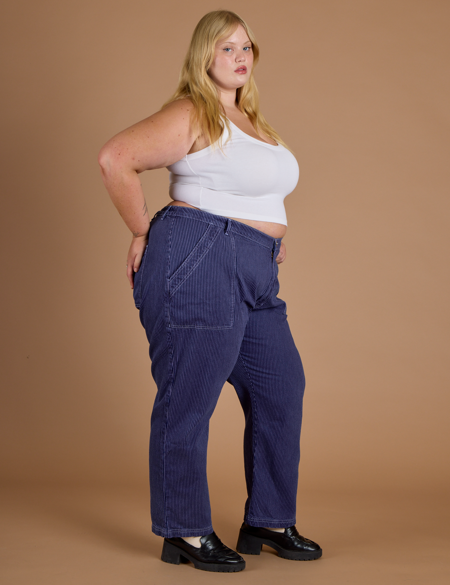 Side view of Railroad Denim Work Pants in Faded Grape Overdye and vintage tee white Cropped tank on Juliet