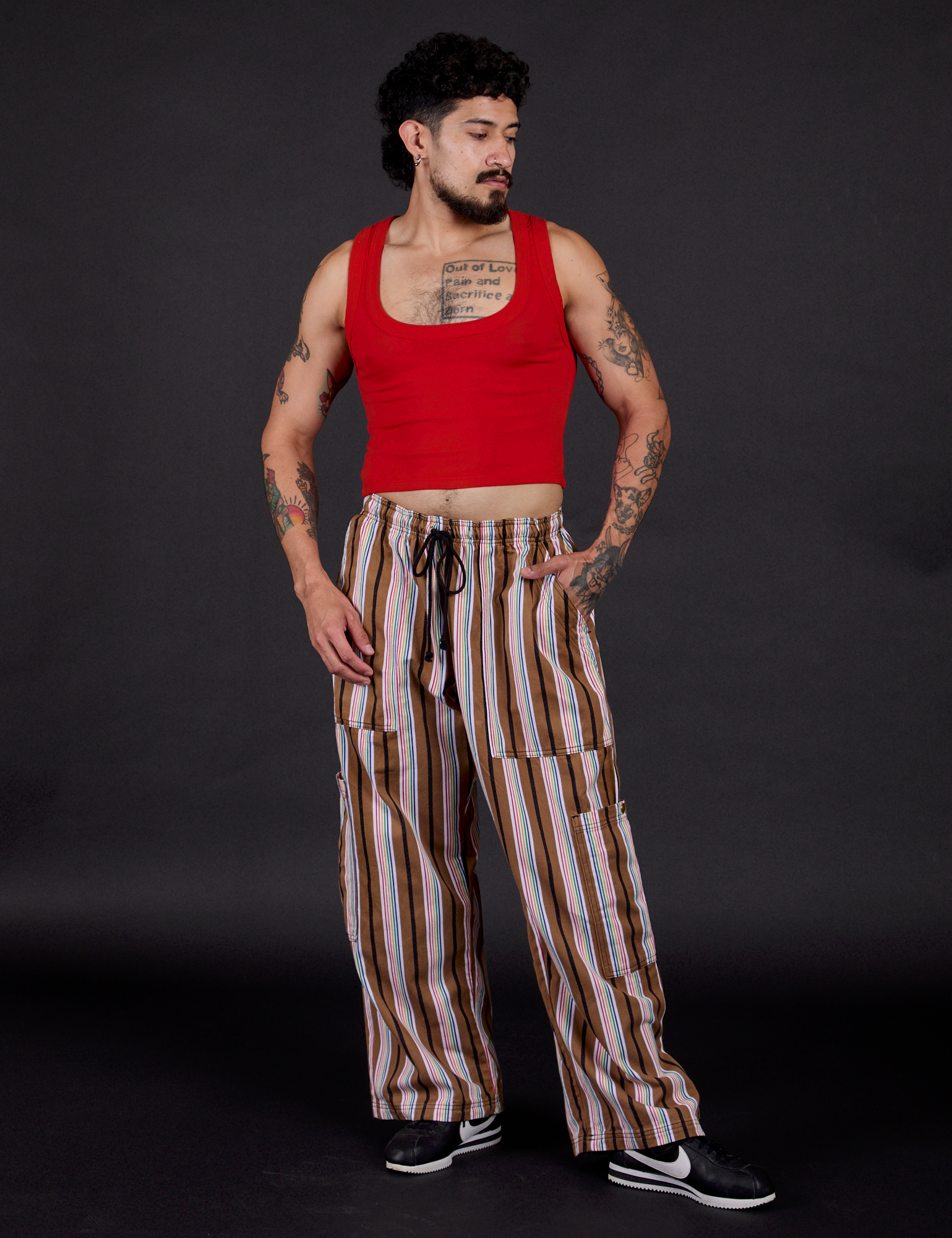 Jesse is 5'8" and wearing S Striped Drop Pocket Pants in Retro Rainbow paired with a mustang red Cropped Tank