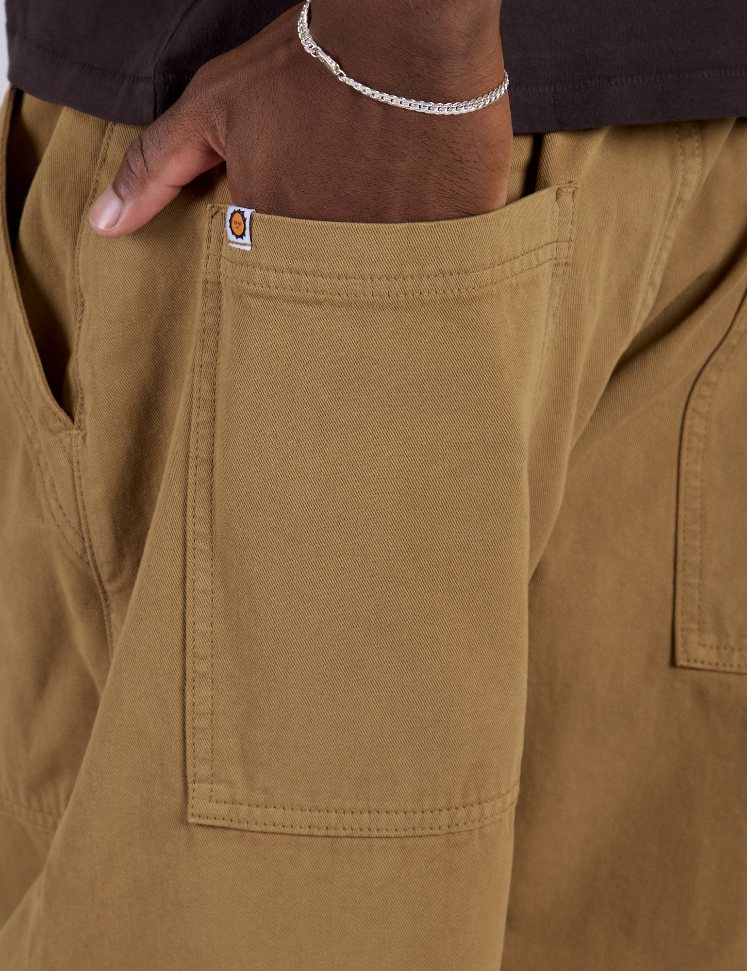 Close up of Isaac's hand in the back pocket of Drop Pocket Cargo Pants in Desert Brown