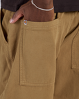 Close up of Isaac's hand in the back pocket of Drop Pocket Cargo Pants in Desert Brown